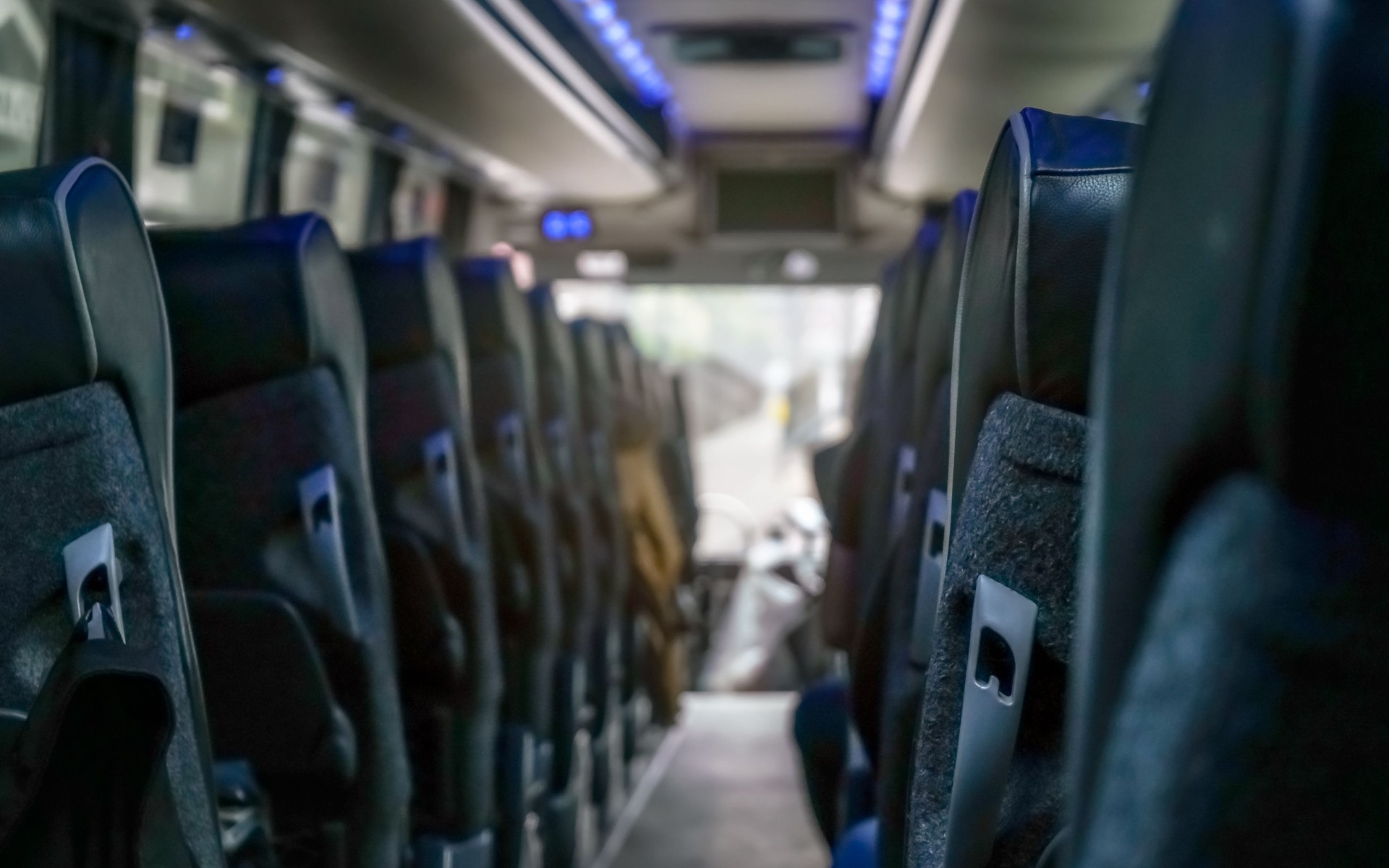 View from back seat at coach bus, more seats in blurred background